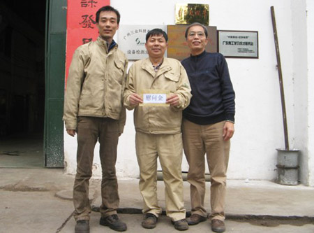 公司职工代表（左）、制作部员工易善康（中）、公司工会主席孔庆新（右）在发放现场