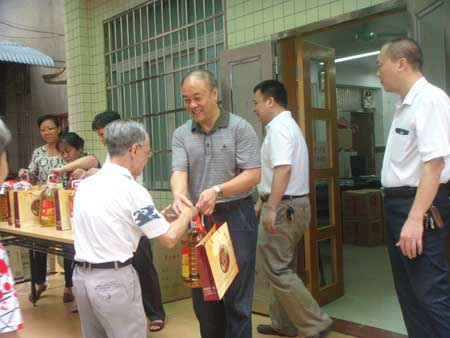 广州三业公司常务副总经理郑全先生为居民送上慰问品