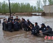 新疆额敏县突降暴雨引发洪水 民警水中拉绳救人